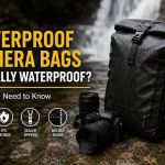 Waterproof camera backpack and camera gear beside a wet stream, illustrating camera bag water protection.